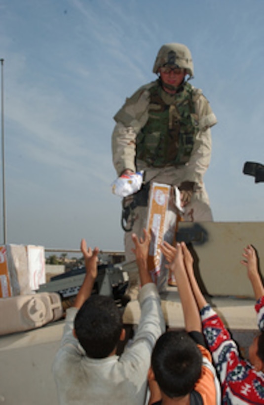 U.S. Army Spc. Seidel hands out frozen chickens to Iraqi citizens during a humanitarian relief effort in the area near Sadr City, Iraq, on Nov. 10, 2004. The soldiers are assigned to the 1st Brigade Reconnaissance Team, Charlie Troop, 10th Cavalry Regiment, 1st Cavalry Division from Fort Hood, Texas, deployed to Iron Horse Base in support of Operation Iraqi Freedom. 