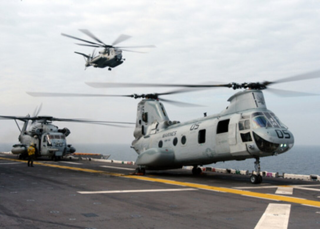 Two U.S. Marine CH-53E Super Stallions and a CH-46 Sea Knight (right) prepare to transport Marines from the flight deck of the USS Kearsarge (LHD 3) to Onslow Bay, N.C., for a beach assault exercise on Nov. 22, 2004. The Kearsarge Expeditionary Strike Group and the embarked 26th Marine Expeditionary Unit are conducting initial integrated training in preparation for a scheduled deployment. 
