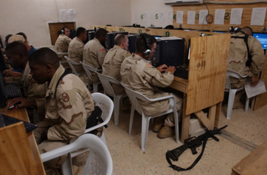 U.S. Army soldiers e-mail their families before eating Thanksgiving dinner at Camp Cobra in Iraq on Nov. 25, 2004. The soldiers are assigned to the 30th Brigade Combat Team, a comprised unit made up of over 5000 North Carolina National Guard personnel. 