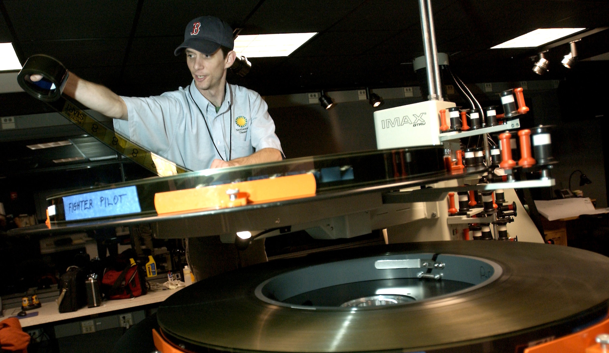 CHANTILLY, Va. -- Peter Gabriel prepares to thread film from the new IMAX movie "Fighter Pilot: Operation Red Flag" into the projector.  The movie chronicles the experience of Capt. John Stratton as he participates in his first Red Flag exercise.  The film movie made its premier Dec. 2 at the National Air and Space Museum here.  (U.S. Air Force photo by Master Sgt. James Varhegyi) 