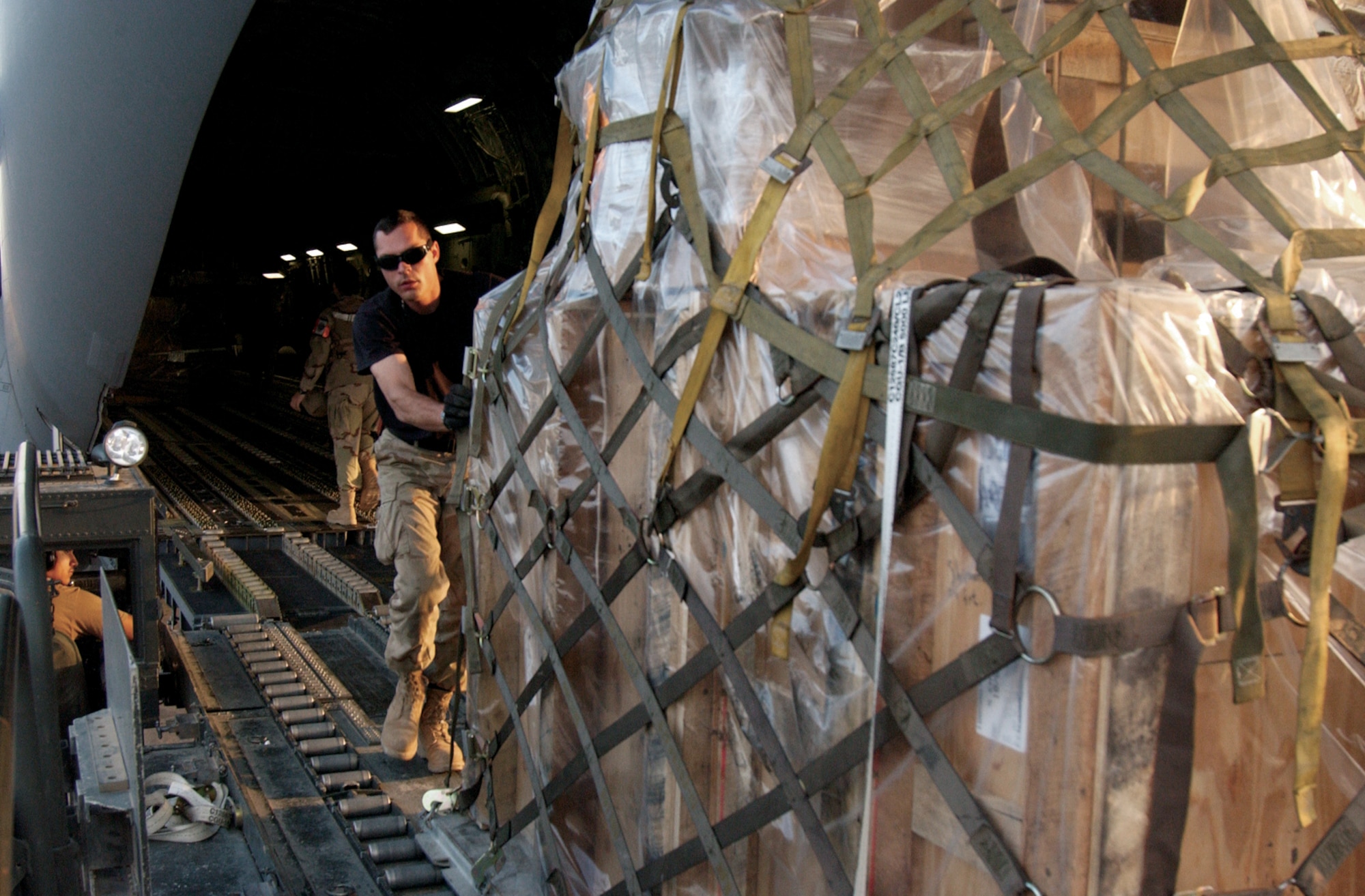 BALAD AIR BASE, Iraq -- Staff Sgt. Tony Forcier rolls cargo off a C-17 Globemaster III on the flightline here. Sergeant Forcier is assigned to the 332nd Expeditionary Logistics Readiness Squadron and is from Dover Air Force Base, Del. (U.S. Air Force Photo by Master Sgt. David Reagan)