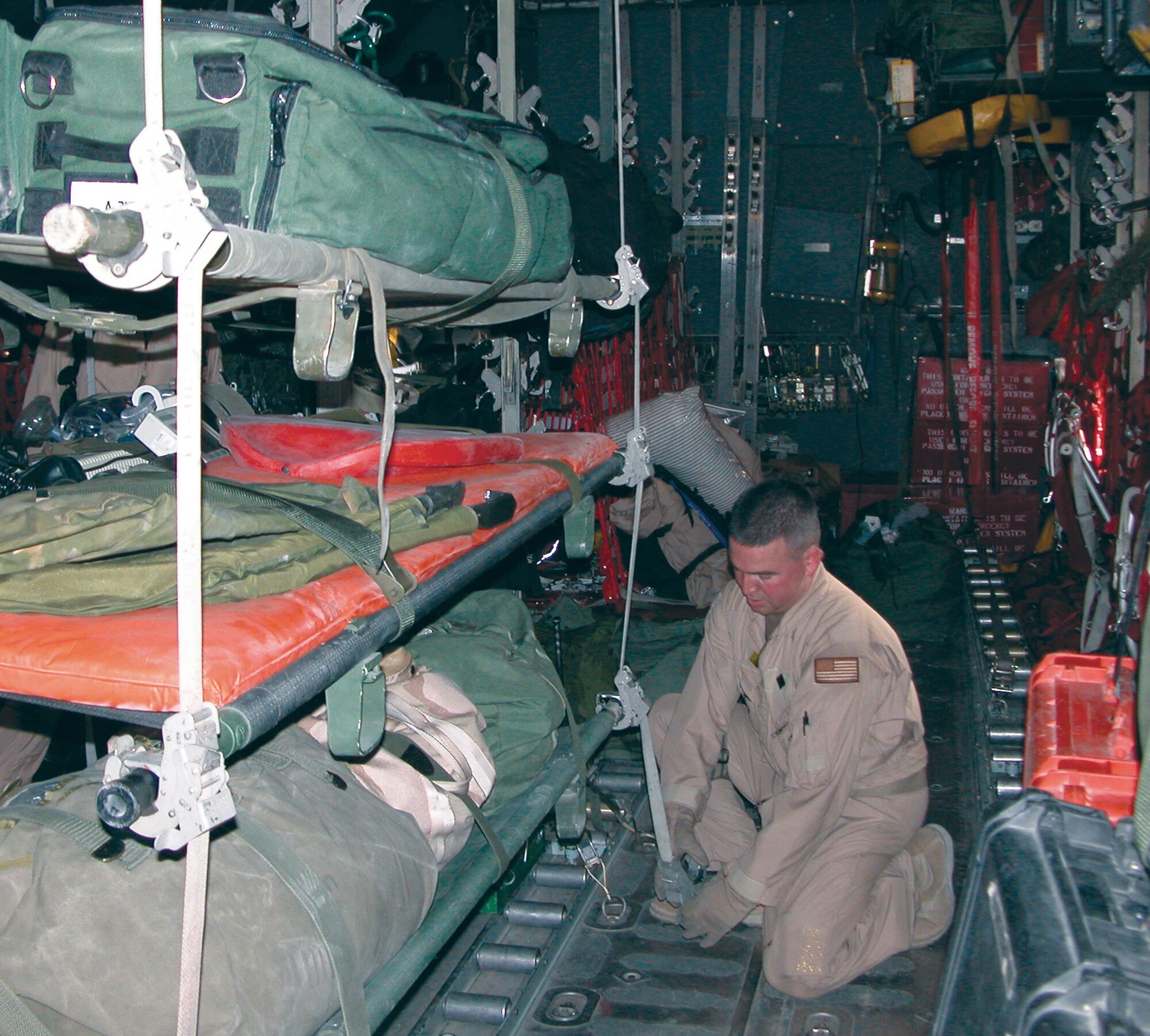 SOUTHWEST ASIA -- Master Sgt. Maxie Gainey secures litters holding aeromedical evacuation supplies during a mission.  He is a C-130 Hercules loadmaster deployed from Pope Air Force Base, N.C.  (U.S. Air Force photo by Capt. Mae-Li Allison)