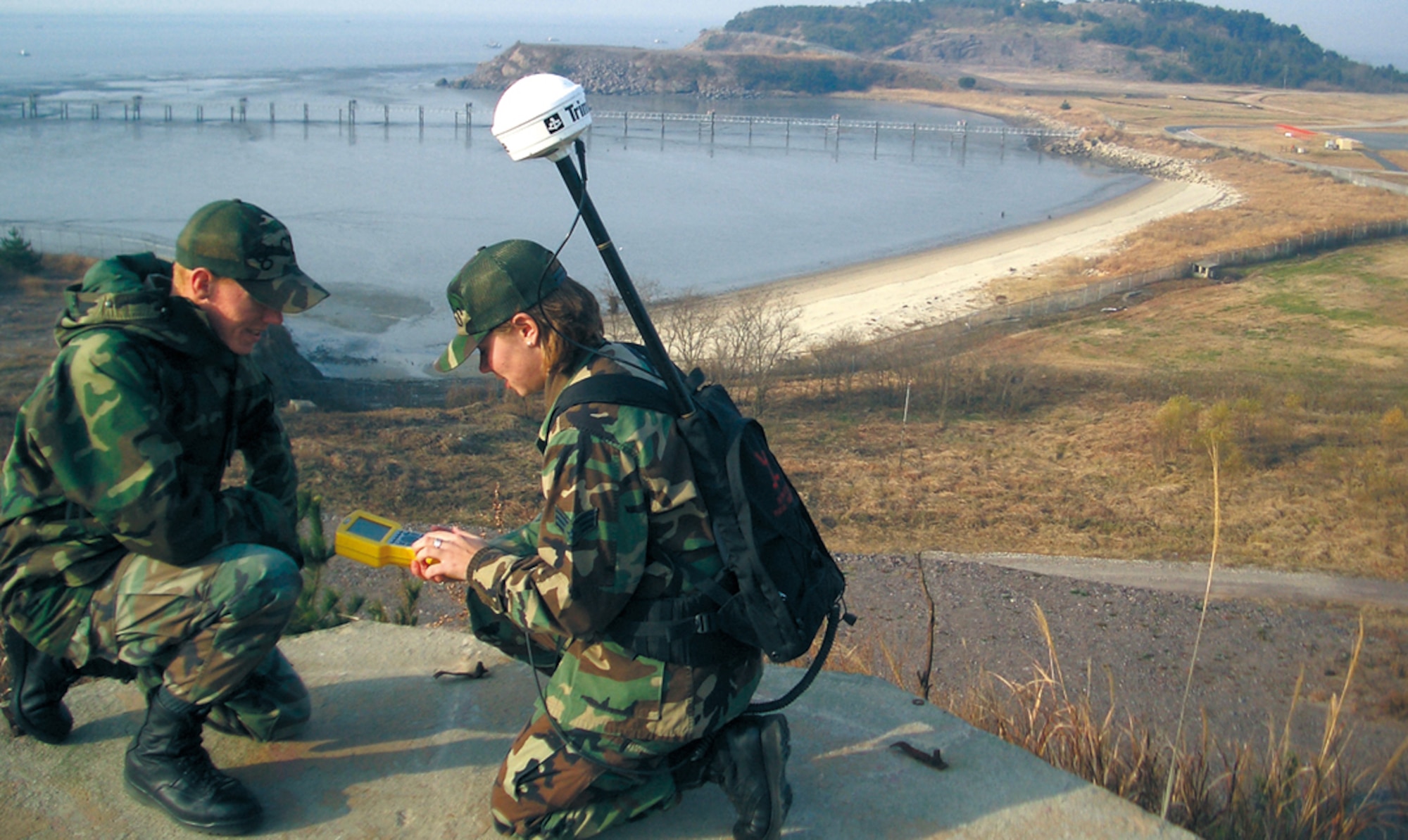 KUNSAN AIR BASE, South Korea -- Airman 1st Class Shannon Davis watches as Senior Airman Erin Farris uses a Global Positioning System hand-held unit to map a part of the base here during a GeoBase survey.  They are assigned to the  8th Civil Engineer Squadron.  (U.S. Air Force photo by David Blumberg) 