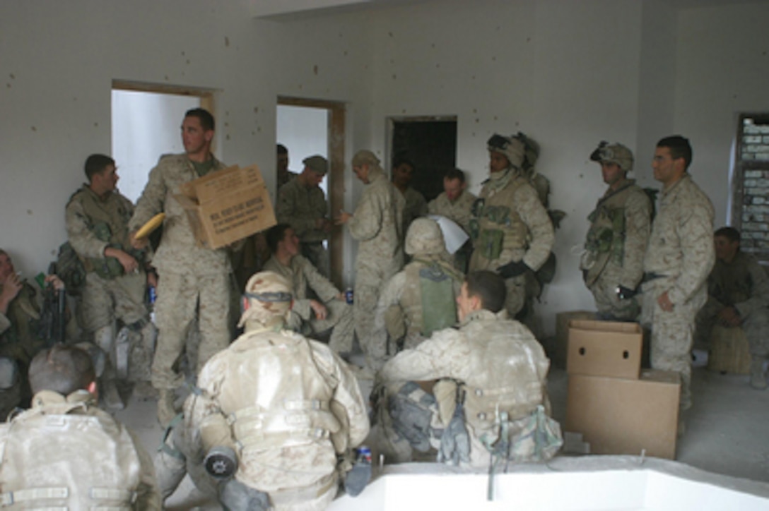 U.S. Marines receive mail from home from friends and family during Operation al Fajr (New Dawn) in Fallujah, Iraq, on Nov. 14, 2004. The Marines assigned to Regimental Combat Team Seven, 1st Platoon, Charlie Company, 1st Battalion, 3rd Marine Regiment, take turns manning the various gun positions set around the house and on the roof to defend themselves in case of attack during the mail call. 