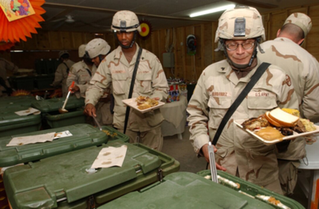 U.S. Army soldiers heap Thanksgiving dinner on their trays at Camp Cobra in Iraq on Nov. 25, 2004. The soldiers are assigned to 30th Brigade Combat Team, a comprised unit made up of over 5000 North Carolina Air National Guard personnel. 