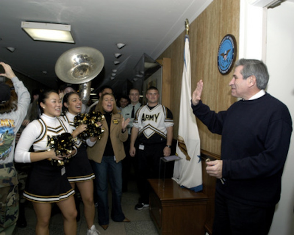 Deputy Secretary of Defense Paul Wolfowitz (right) is greeted outside his Pentagon office by the West Point Academy cheerleaders and band on Dec. 3. 2004. The cadets are promoting esprit de corps in the Pentagon for the upcoming Army/ Navy football game on Dec 4, 2004. 