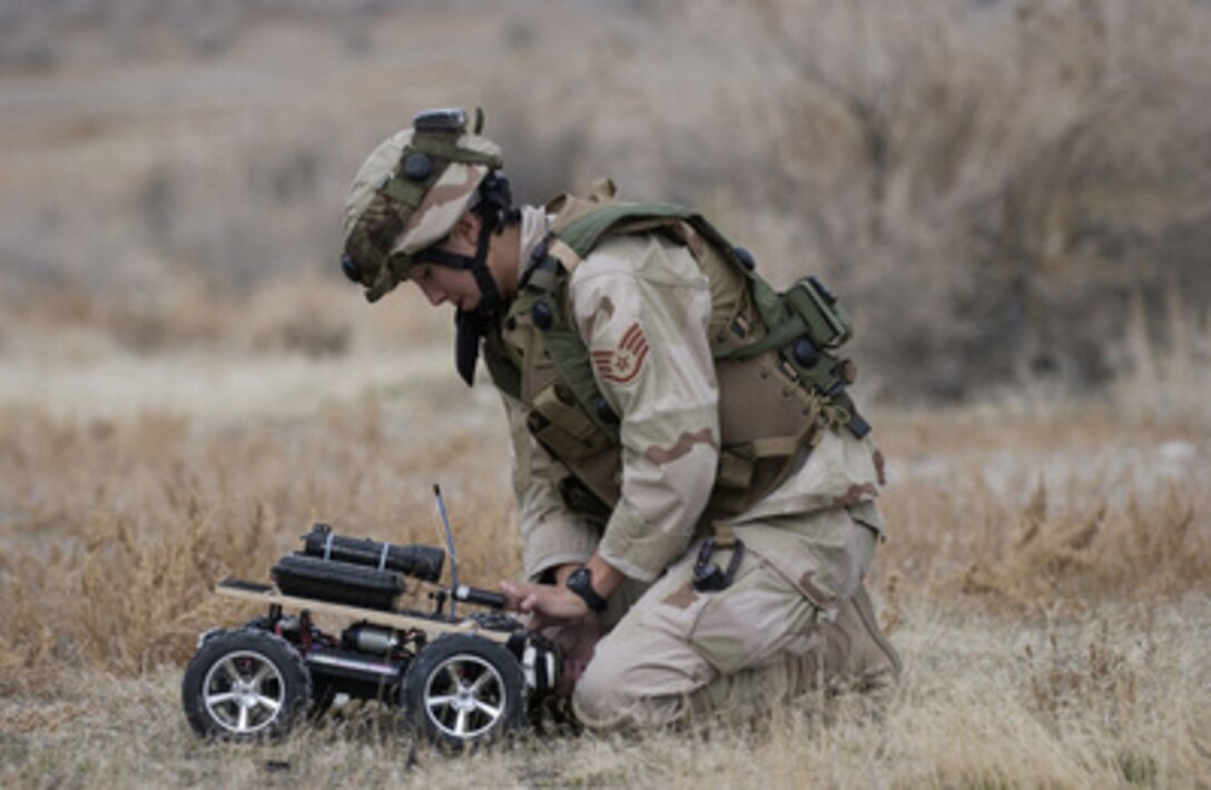 U.S. Air Force Staff Sgt. Lilly Smith attaches C-4 explosive to the front of a remote controlled vehicle used by explosive ordnance disposal personnel to deal with roadside improvised explosive devices on Nov. 10, 2004. Explosive ordnance disposal troops are using live ordnance and explosives to train during a three-day exercise at the Utah Test and Training Range near Hill Air Force Base. Smith is attached to the explosive ordnance disposal team at Hill. 