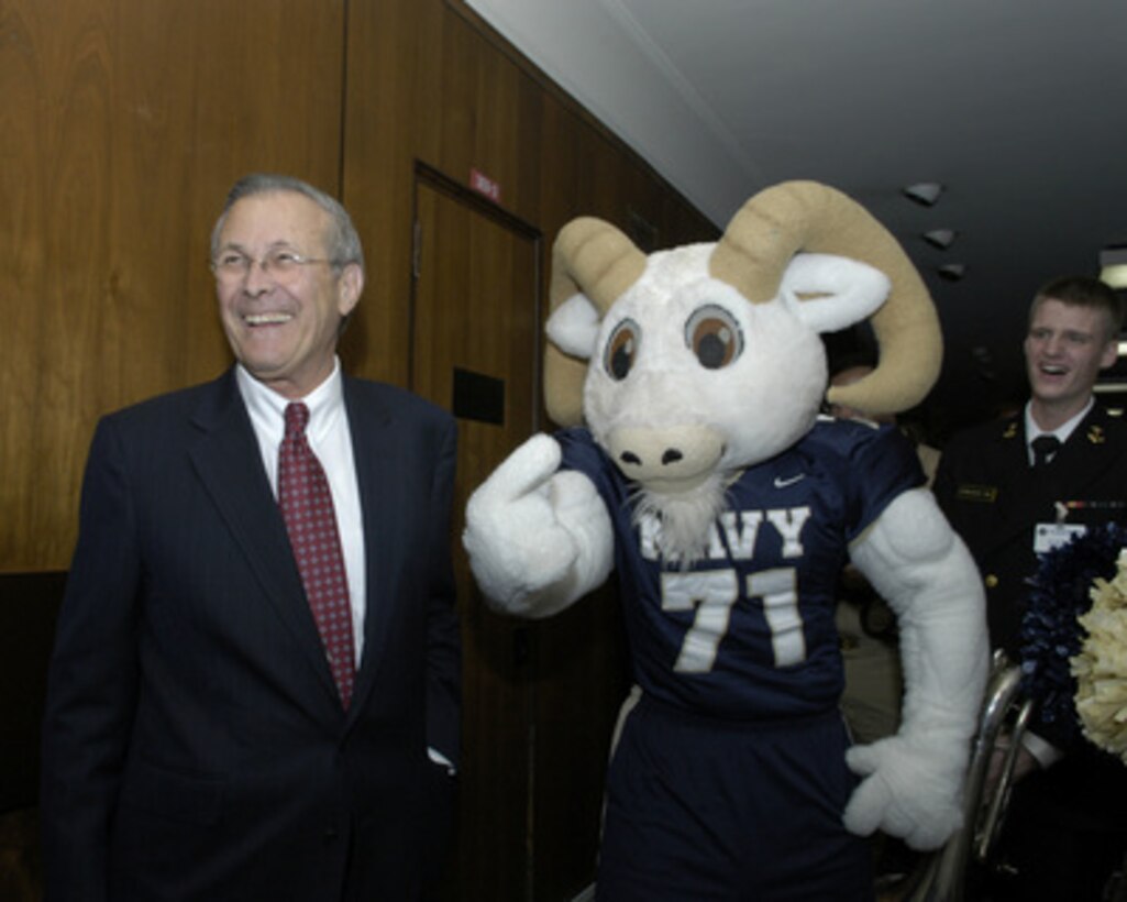 Secretary of Defense Donald H. Rumsfeld is greeted outside his Pentagon office by Navy Mascot "Bill the Goat" and the Naval Academy Band on Dec. 2. 2004. Bill, the band and Naval Academy cheerleaders are promoting esprit de corps in the Pentagon for the upcoming Army/Navy football game on Dec 4, 2004. 