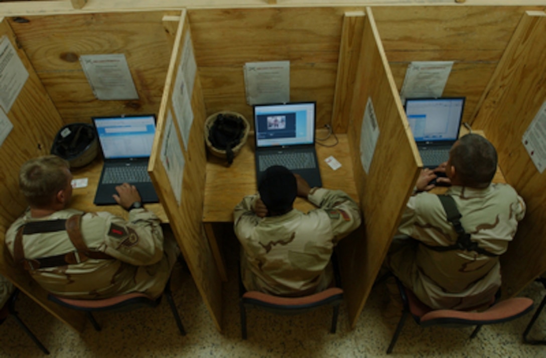 Soldiers and airmen with the 30th Brigade Combat Team check their e-mail in the Morale, Welfare and Recreation center located on base at Camp Caldwell in Iraq on Nov. 19, 2004. 