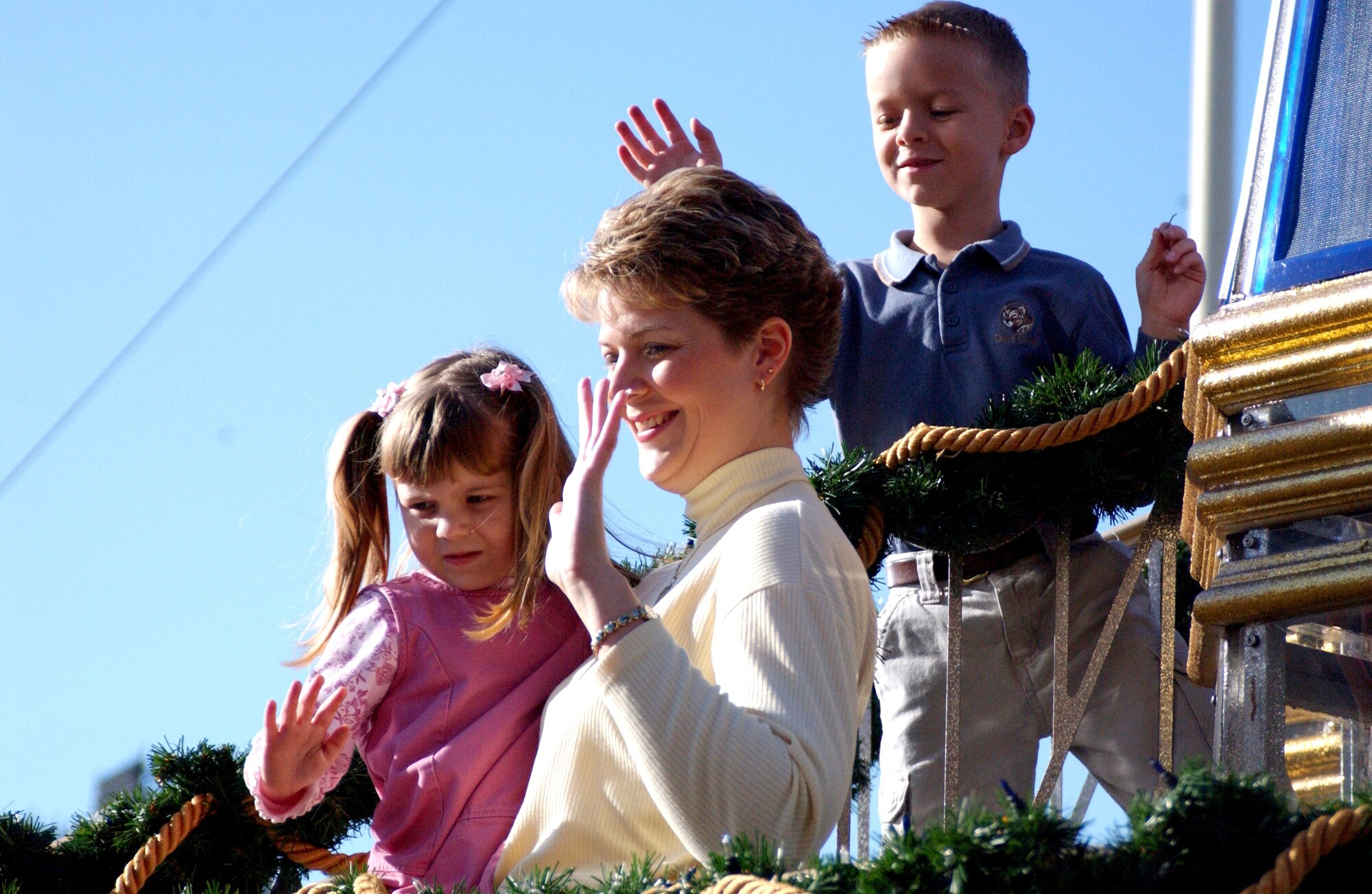 ORLANDO, Fla. -- Lisa Costin holds her daughter, Samantha, and waves as they and her son, Dustin, are greeted by the crowd around a military appreciation float at Walt Disney World.  Mrs. Costin's husband is a Sailor on the USS Kennedy, and has been deployed to and around the Persian Gulf since June.  (Courtesy photo)
