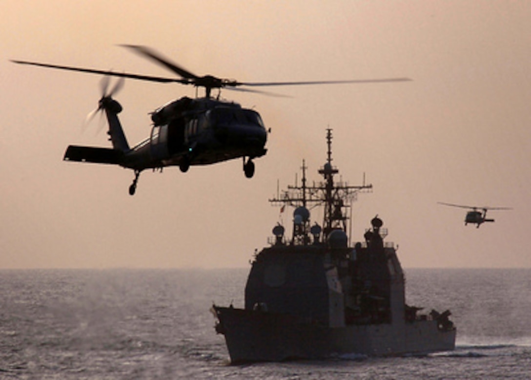 Two MH-60S Knighthawk helicopters swarm around the USS Monterey (CG 61) to go pickup cargo during a vertical replenishment operation while underway in the Persian Gulf on Nov. 27, 2004. The Ticonderoga Class guided missile cruiser is deployed in support of the Global War on Terror. The Knighthawks are assigned to Helicopter Combat Support Squadron 6. 