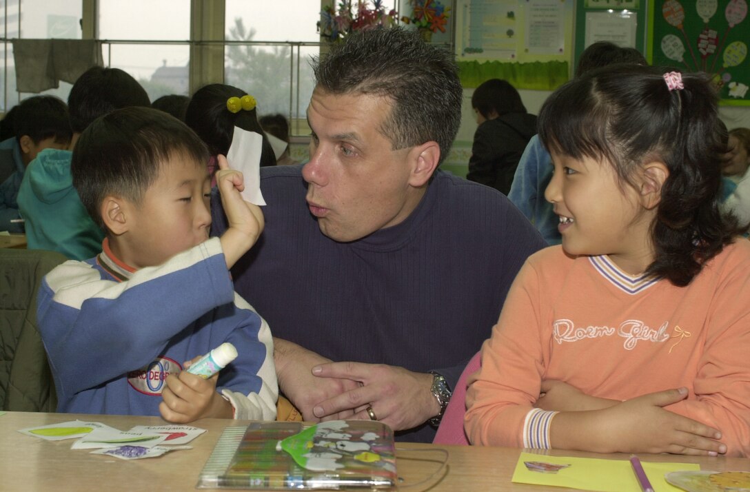 SUWON CITY, South Korea -- Master Sgt. John Liss helps teach English to South Korean students here Dec. 4.  Once a month Airmen from nearby Osan Air Base visit an elementary school here.  The program has been active for five months.  Sergeant Liss is assigned to the 51st Medical Group.  (U.S. Air Force photo by Staff Sgt. Raheen Moore)