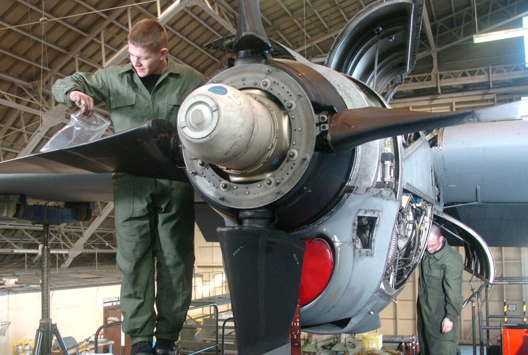 YOKOTA AIR BASE, Japan -- Airman 1st Class Matthew McGonagle (left) and Staff Sgt. Philip Farnstrom inspect a C-130 Hercules engine during an annual check here. Pacific Air Force C-130s undergo a major inspection once a year to ensure that the fleet is in top condition.  The Airmen are engine specialists assigned to the 374th Maintenance Squadron.  (U.S. Air Force photo by Master Sgt. Val Gempis)