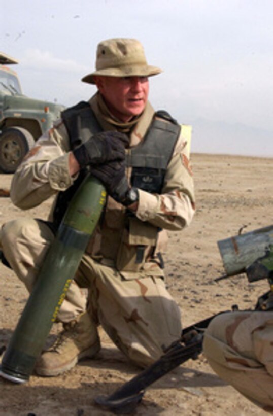 U.S. Air Force Staff Sgt. Derek Keener prepares a 105mm rocket to be fired at a weapons cache at the East River Range near Bagram Airfield, Afghanistan, on Dec. 2, 2004. Members of the Air Force's 455th Explosive ordnance Group set C-4 charges on the cache in order to destroy it. 