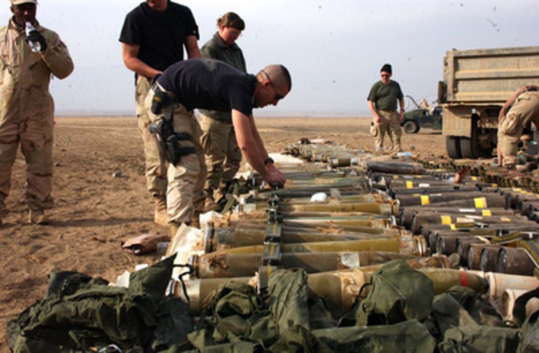 U.S. Air Force airmen from the 455th Explosive Ordnance Group, Explosive Ordnance Disposal set C-4 charges on a weapons cache to be destroyed at the East River Range, Bagram Airfield, Afghanistan, on Dec. 2, 2004. 