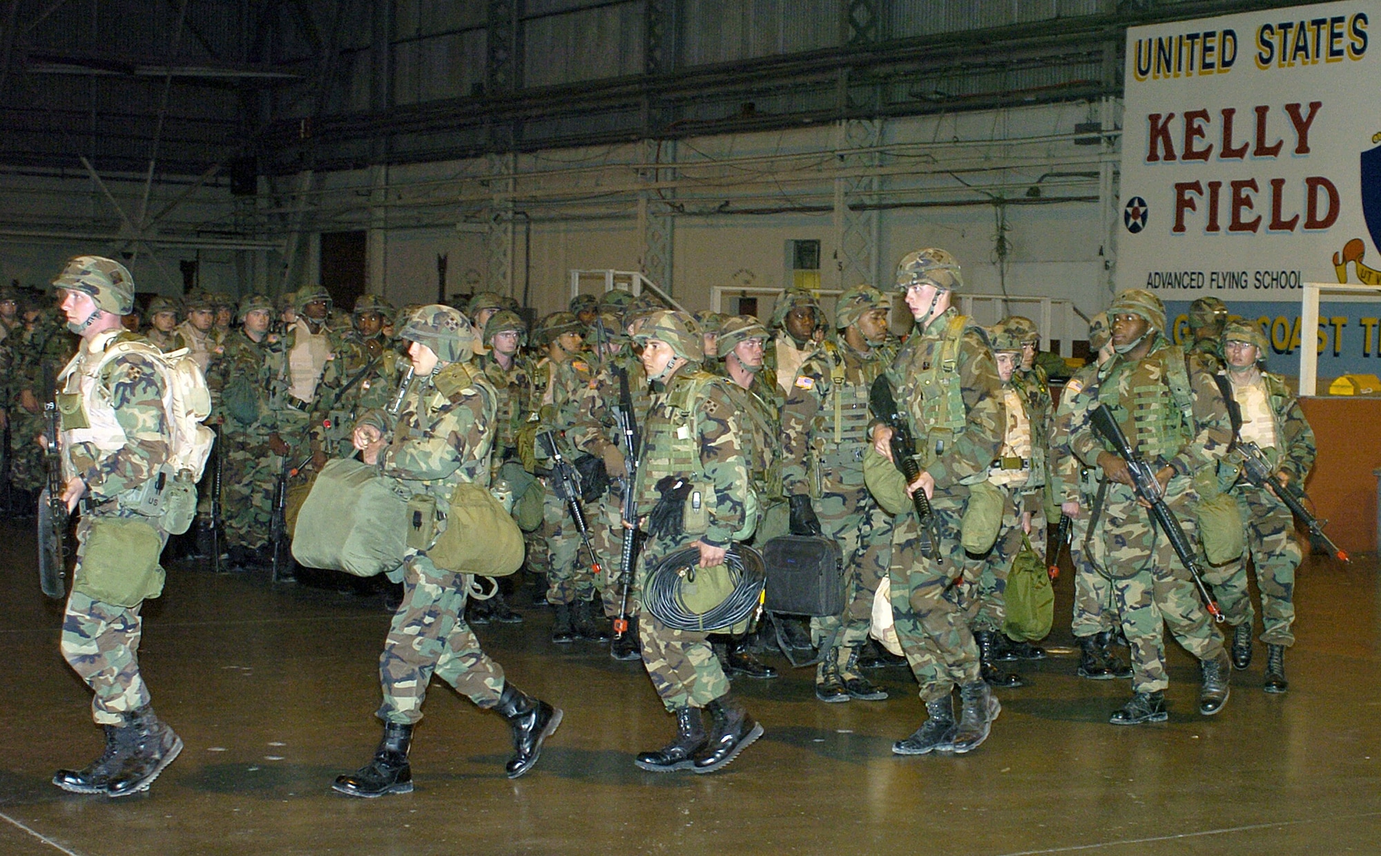 LACKLAND AIR FORCE BASE, Texas -- Soldiers from the 4th Infantry Division out of Fort Hood, Texas, quickly move out of a hangar here to be driven to a quick reaction force exercise here Dec. 8. The mission was to provide a flexible and responsive unit to a specific region in the event of a domestic threat or incident. The exercise here trained the Soldiers to prepare for homeland defense missions. (U.S. Air Force photo by Staff Sgt. Derrick C. Goode)