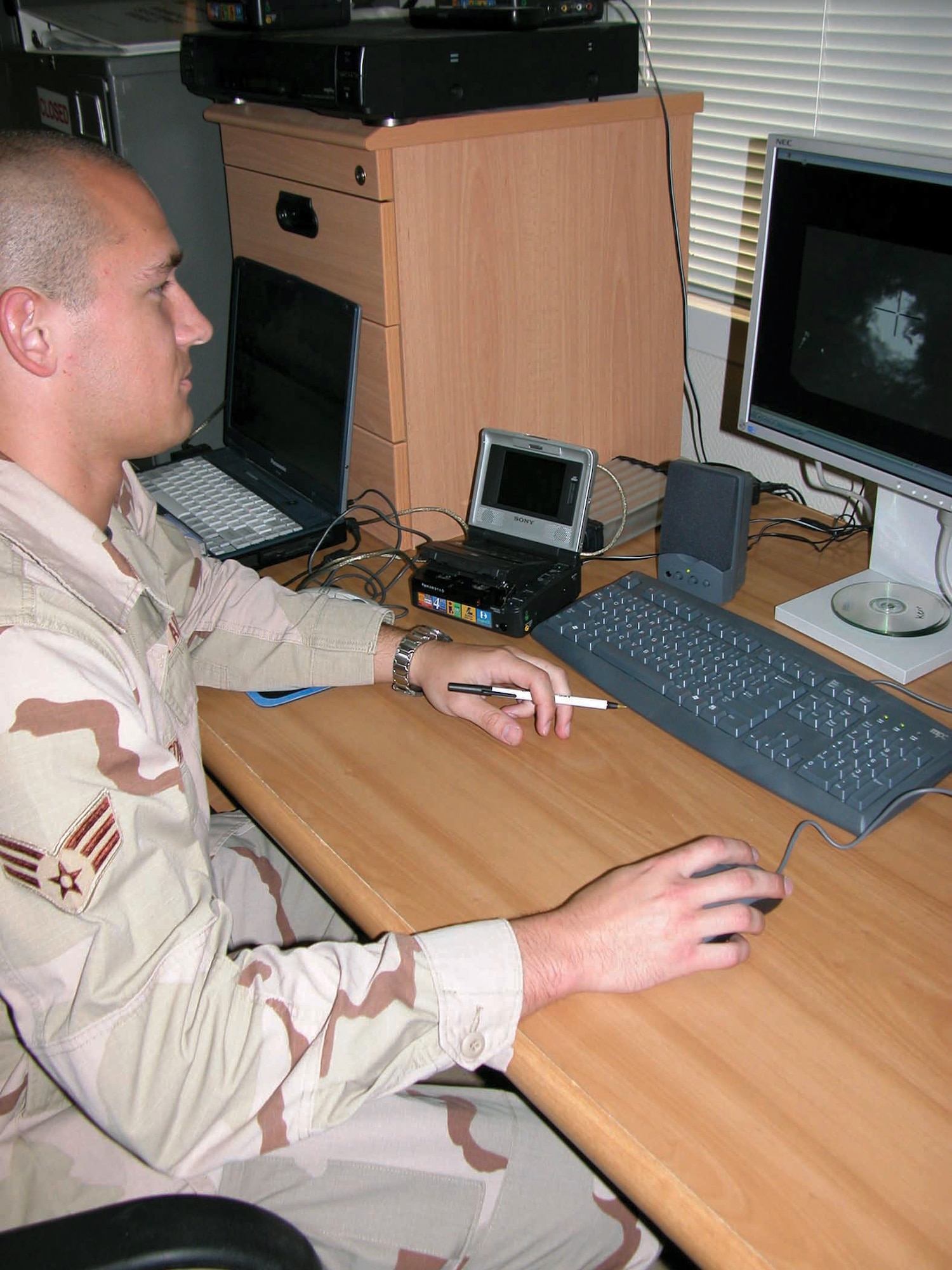 SOUTHWEST ASIA -- Senior Airman Michael Edwards views weapon systems video taken from an F-15E Strike Eagle mission.  Airman Edwards, a graphics artist, packages the videos so evaluators can determine the effectiveness of air strikes.  He is deployed from Seymour Johnson Air Force Base, N.C.  (U.S. Air Force photo by Capt. Mae-Li Allison)