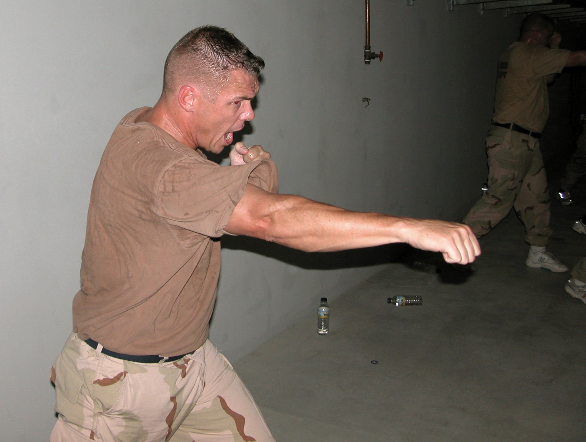 SOUTHWEST ASIA -- Tech. Sgt. Scott Butler, a deployed firefighter, practices during the final Marine Corps Martial Arts Program class before he and fellow firefighters were certified as "tan belts" in the program.  Marine Sgt. Luis Mercado teaches the course in his off-duty time.  (U.S. Air Force photo by Staff Sgt. Bryan Bouchard)