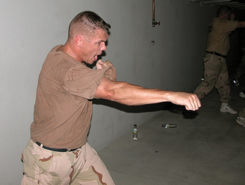 SOUTHWEST ASIA -- Tech. Sgt. Scott Butler, a deployed firefighter, practices during the final Marine Corps Martial Arts Program class before he and fellow firefighters were certified as "tan belts" in the program.  Marine Sgt. Luis Mercado teaches the course in his off-duty time.  (U.S. Air Force photo by Staff Sgt. Bryan Bouchard)