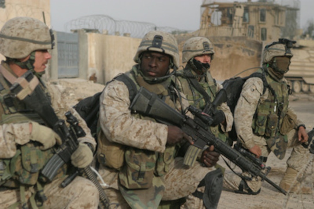 U.S. Marines prepare to step off on a patrol through the city of Fallujah, Iraq, to clear the city of insurgent activity and weapons caches as part of Operation al Fajr (New Dawn) on Nov. 26, 2004. The Marines are (from left to right) Platoon Sergeant Staff Sgt. Eric Brown, Machine Gun Section Leader Sgt. Aubrey McDade, Radio Operator Cpl. Steven Archibald, and Combat Engineer Lance Cpl. Robert Coburn. All are assigned to 1st Battalion, 8th Marine Regiment, 1st Marine Division conducting security and stabilization operations in the Al Anbar Province of Iraq. 