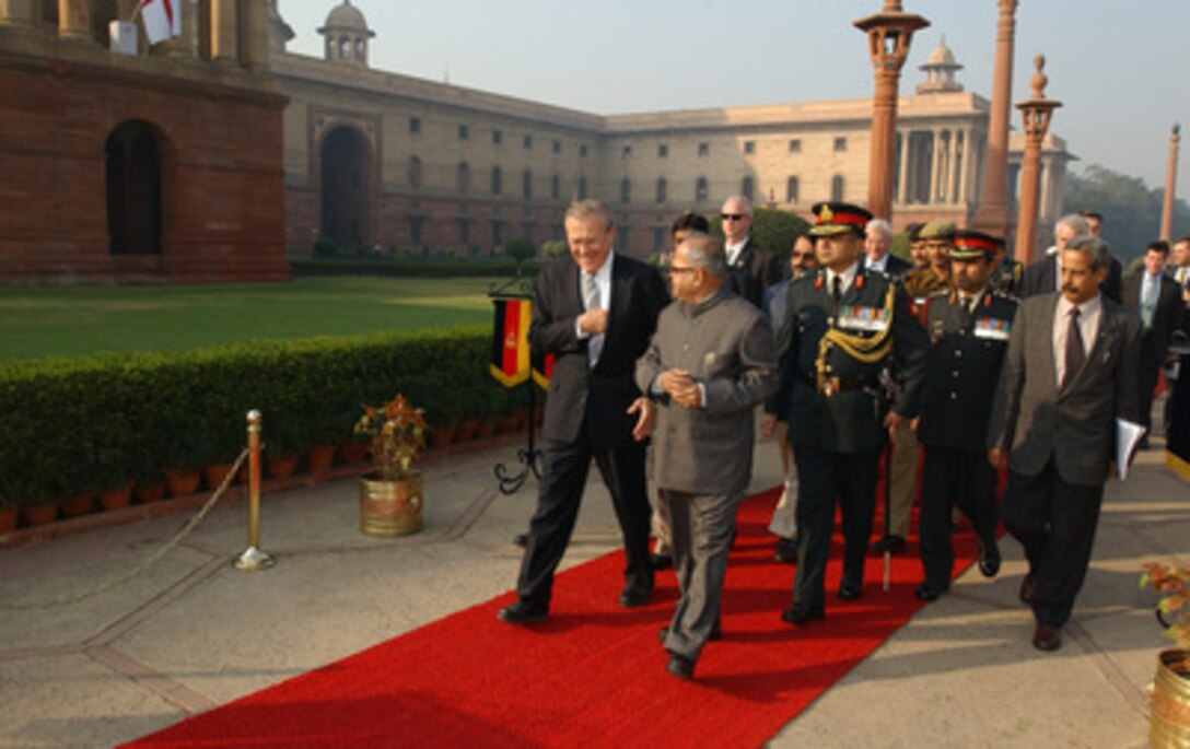 Minister of Defense Pranab Mukherhee (right foreground) escorts Secretary of Defense Donald H. Rumsfeld as he arrives at the South Block building in New Delhi, India, on Dec. 9, 2004. Rumsfeld is in India to meet with India's senior leadership to discuss defense issues of mutual interest and the war on terror. 