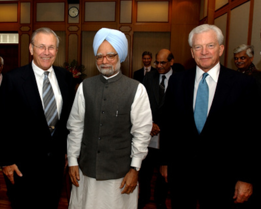 Secretary of Defense Donald H. Rumsfeld (left), India's Prime Minister Manmohan Singh (center) and U.S. Ambassador to India David Mulford (right) pose for photographers after their meeting in New Delhi, India, on Dec. 9, 2004. Rumsfeld is in India to meet with Singh and other senior leaders to discuss defense issues of mutual interest and the war on terror. 