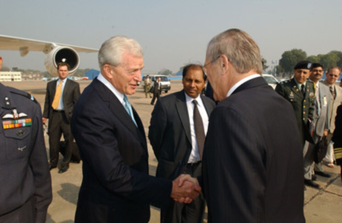 Secretary of Defense Donald H. Rumsfeld (right) shakes hands with U.S. Ambassador to India David Mulford (left) before departing New Delhi, India, on Dec. 9, 2004. Rumsfeld visited India to meet with India's senior leadership to discuss defense issues of mutual interest and the war on terror. 