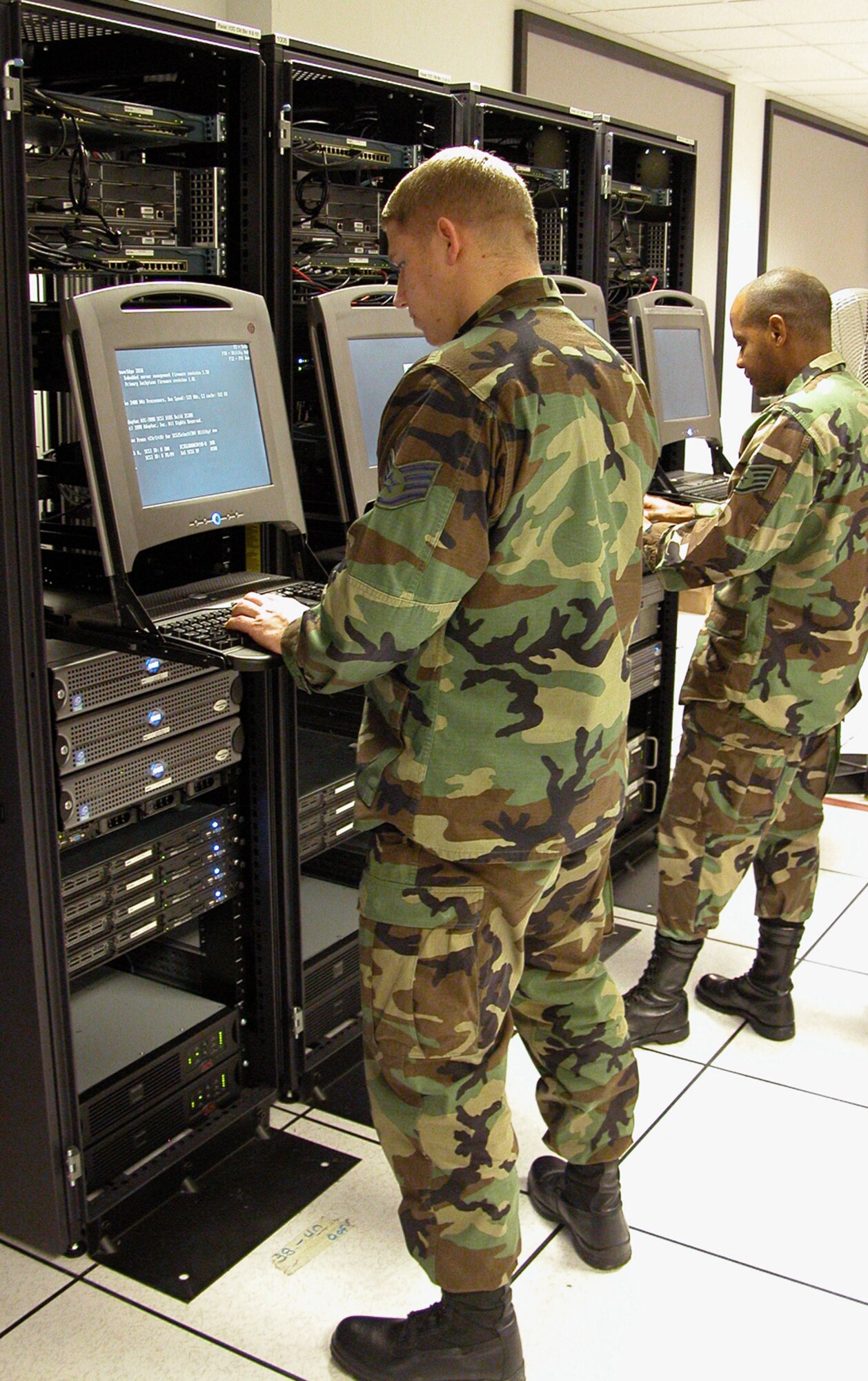 SCOTT AIR FORCE BASE, Ill. -- Staff Sgts. John Cooper (left) and David Jackson from the Air Mobility Command network operations and security center battle &quot;hackers&quot; in Air Force Communications Agency's technology interoperability facility here.  (U.S. Air Force photo by Gerald Sonnenberg)
