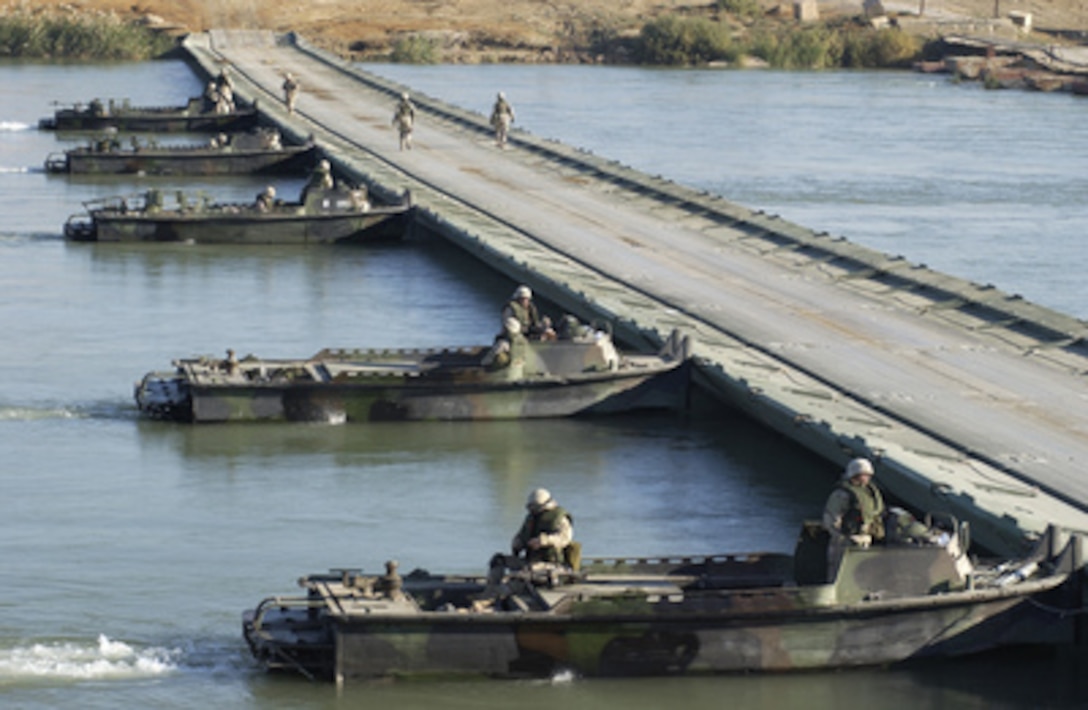 U.S. Army soldiers with the 502nd Engineer Company position their bridge erection boats against the current as they prepare to remove an assault float-bridge from the Euphrates River near Al Qaim, Iraq, on Dec. 2, 2004. 
