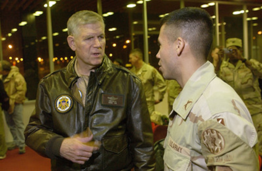 Chairman of the Joint Chiefs of Staff Gen. Richard B. Myers, U.S. Air Force, speaks to an Army officer during a stopover at Shannon Airport, Ireland, on Dec. 13, 2004. Myers' plane was refueling at the airport en route to the Middle East for a United Services Organization tour. Myers is taking Blake Clarke, John Elway, Leann Tweedon and Robin Williams on the USO tour to meet, entertain and thank the deployed troops. The soldier is returning stateside from his deployment to Iraq. 