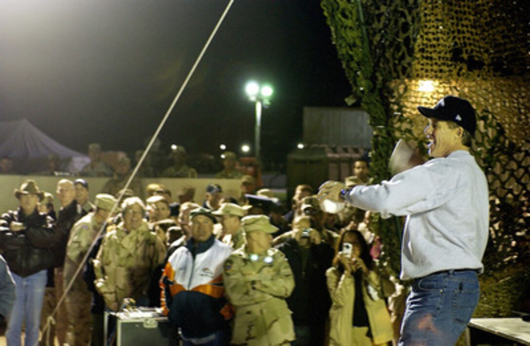 Hall of Fame Quarterback John Elway gives it a pump fake before throwing a football to troops at Camp Virginia, Kuwait, during a United Services Organization tour on Dec. 13, 2004. Elway joined Chairman of the Joint Chiefs of Staff Gen. Richard B. Myers, U.S. Air Force, Blake Clarke, Leann Tweedon and Robin Williams on the USO tour to meet, entertain and thank the deployed troops. 