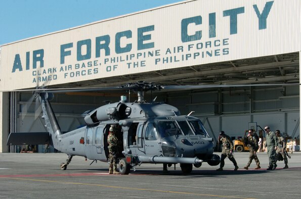 CLARK AIRFIELD, Philippines -- Airmen board an HH-60 Pave Hawk helicopter from the 33rd Rescue Squadron at Kadena Air Base, Japan.  U.S. military troops are providing humanitarian assistance and disaster relief to residents of Quezon Province, where widespread flooding displaced about 168,000 people and left more than 1,400 dead or missing. Air Force and Marine helicopters are flying daily missions to the stricken areas. (U.S. Air Force photo by Master Sgt. Val Gempis)