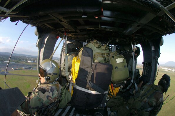 OVER QUEZON PROVINCE, Philippines -- An HH-60 Pave Hawk helicopter from the 33rd Rescue Squadron at Kadena Air Base, Japan, returns to Clark Airfield, Phillipines, after delivering supplies during typhoon relief operations Dec 14. About 600 U.S. military troops are providing humanitarian assistance and disaster relief to residents of Quezon Province where widespread flooding displaced about 168,000 people and left more than 1,400 dead or missing.  Air Force and Marine helicopters are flying daily missions to the stricken areas. (U.S. Air Force photo by Master Sgt. Val Gempis)