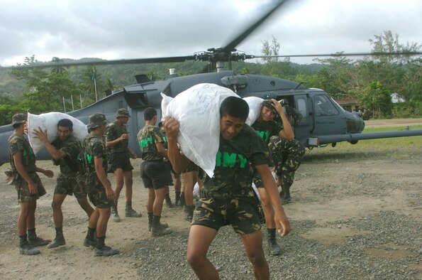 REAL CITY, Philippines -- Philippine servicemembers unload sacks of canned goods, rice and flour here from an HH-60 Pave Hawk helicopter from the 33rd Rescue Squadron at Kadena Air Base, Japan.  About 600 U.S. servicemembers are providing humanitarian assistance and typhoon relief to residents of Quezon Province where widespread flooding displaced about 168,000 people and left more than 1,400 dead or missing.  Air Force and Marine helicopters are flying daily missions to the stricken areas. (U.S. Air Force photo by Master Sgt. Val Gempis)