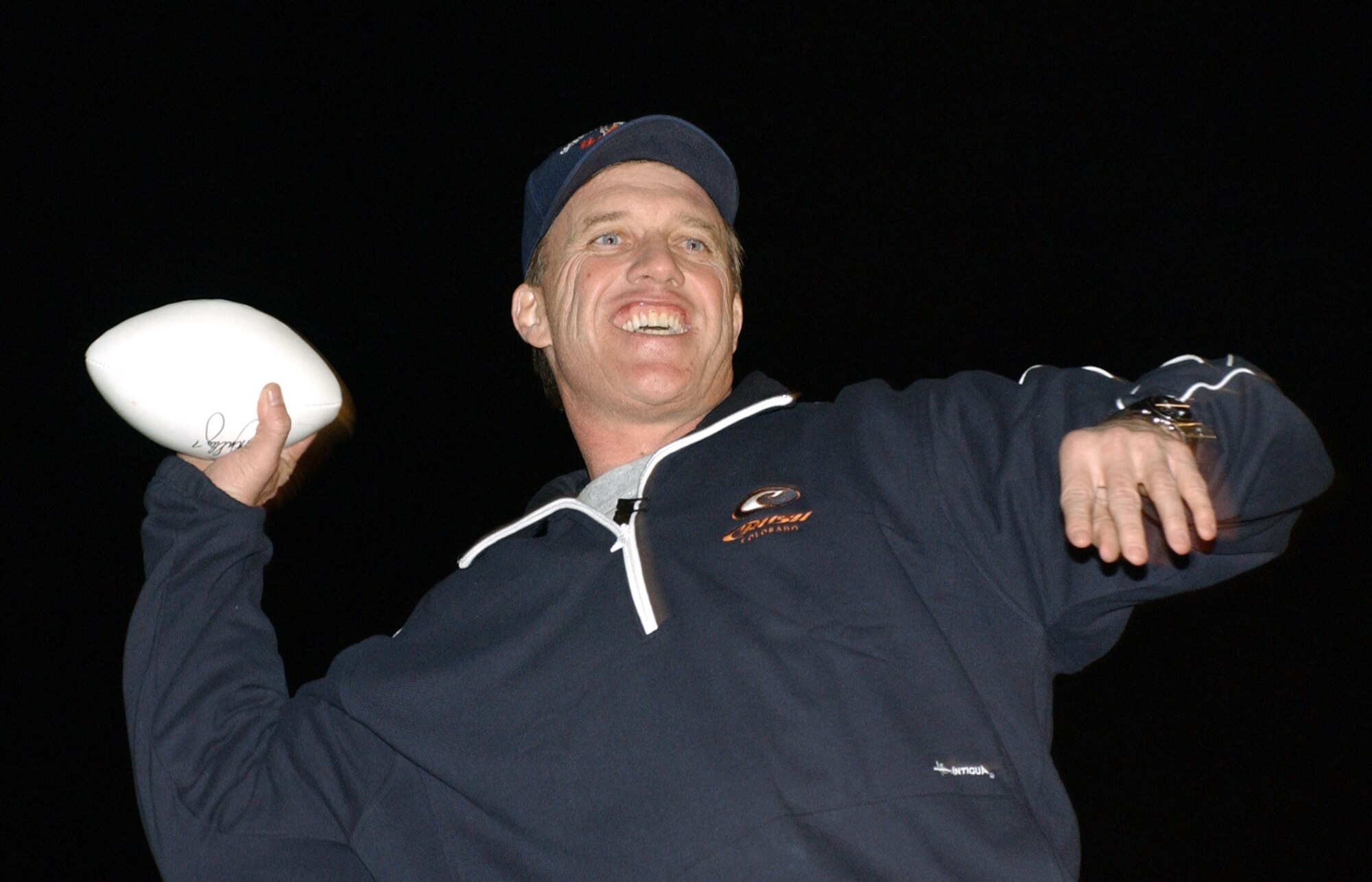 BALAD AIR BASE, Iraq -- John Elway tosses footballs to the crowd during the Chairman's United Service Organizations Holiday Tour here Dec. 14. (U.S. Air Force photo by Tech. Sgt. Marc Barnes)
