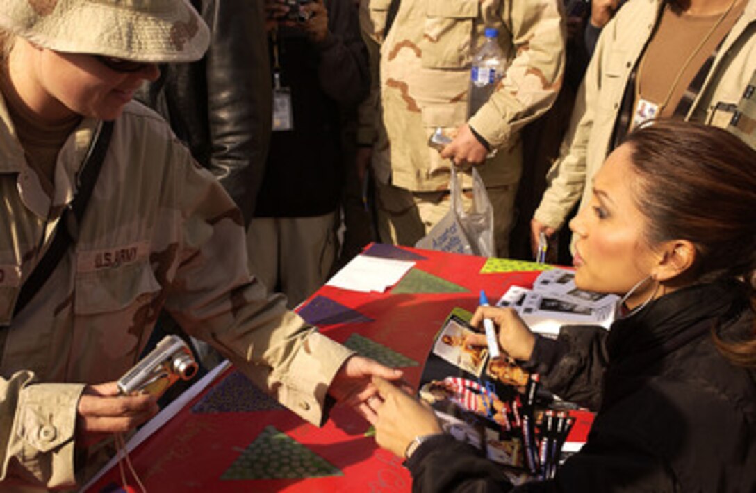 Model and sports show host Leann Tweeden shakes hands with a U.S. soldier while signing autographs during a United Services Organization show at Camp Victory, Iraq, on Dec. 14, 2004. Tweeden joined Chairman of the Joint Chiefs of Staff Gen. Richard B. Myers, U.S. Air Force, Blake Clark, John Elway, and Robin Williams on the USO tour to meet, entertain and thank the deployed troops. 