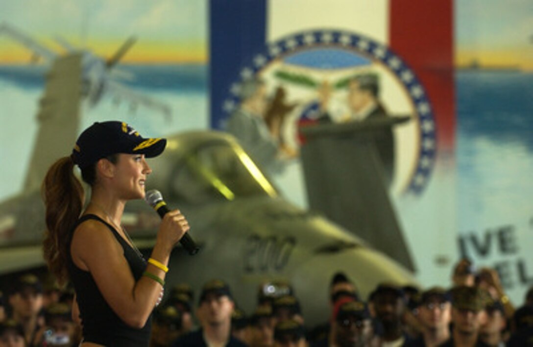 Model and sports show host Leann Tweeden cheers up the hangar bay full of sailors during a United Services Organization show aboard the aircraft carrier USS Harry S. Truman (CV 75) anchored near Manama, Bahrain, on Dec. 15, 2004. Tweeden joined Chairman of the Joint Chiefs of Staff Gen. Richard B. Myers, U.S. Air Force, Blake Clark, John Elway, and Robin Williams on the USO tour to meet, entertain and thank the deployed sailors. 