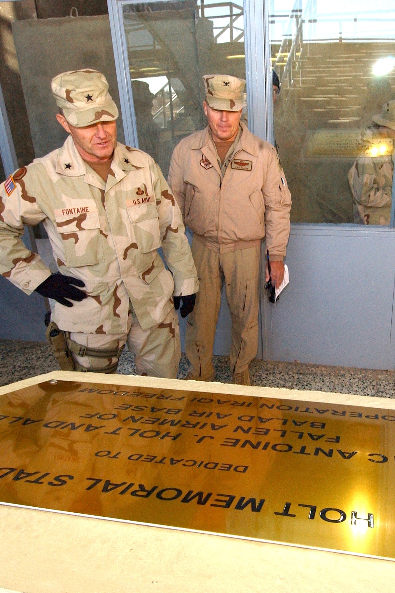 BALAD AIR BASE, Iraq – Army Brig. Gen. Yves Fontaine, commander of the 1st Corps Support Command, and Col. Blair E. Hansen, 332nd Air Expeditionary Wing commander, read a plaque which dedicates the base stadium to Airman 1st Class Antoine J. Holt, who died in April during an attack on the base. (Air Force photo by Tech. Sgt. Robert Jensen)