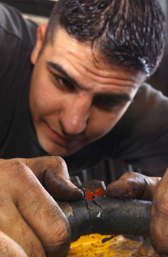 KADENA AIR BASE, Japan. -- Senior Airman Dustin Barnhardt inspects the cracks in a hydraulic line here Dec. 9.  Airman Barnhardt is assigned to the 18 Logistics Readiness Squadron.  (U.S. Air Force photo by Staff Sgt. Chenzira Mallory)