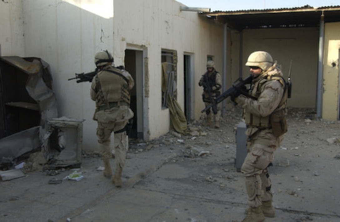 U.S. Navy Chief Petty Officer Ardell Ball (right) leads his team into a former agricultural building in Fallujah, Iraq, on Dec. 9, 2004. The Seabees from Naval Mobile Construction Battalion 23 will assess the building for damage. Ball is a Navy Reserve engineering aid. 