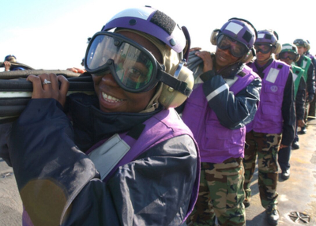 Airman Jahka Gartrell takes part in storing the emergency barricade aboard the aircraft carrier USS Theodore Roosevelt (CVN 71) on Dec. 11, 2004. The Roosevelt is conducting sea trials in the Atlantic Ocean during a scheduled deployment. 