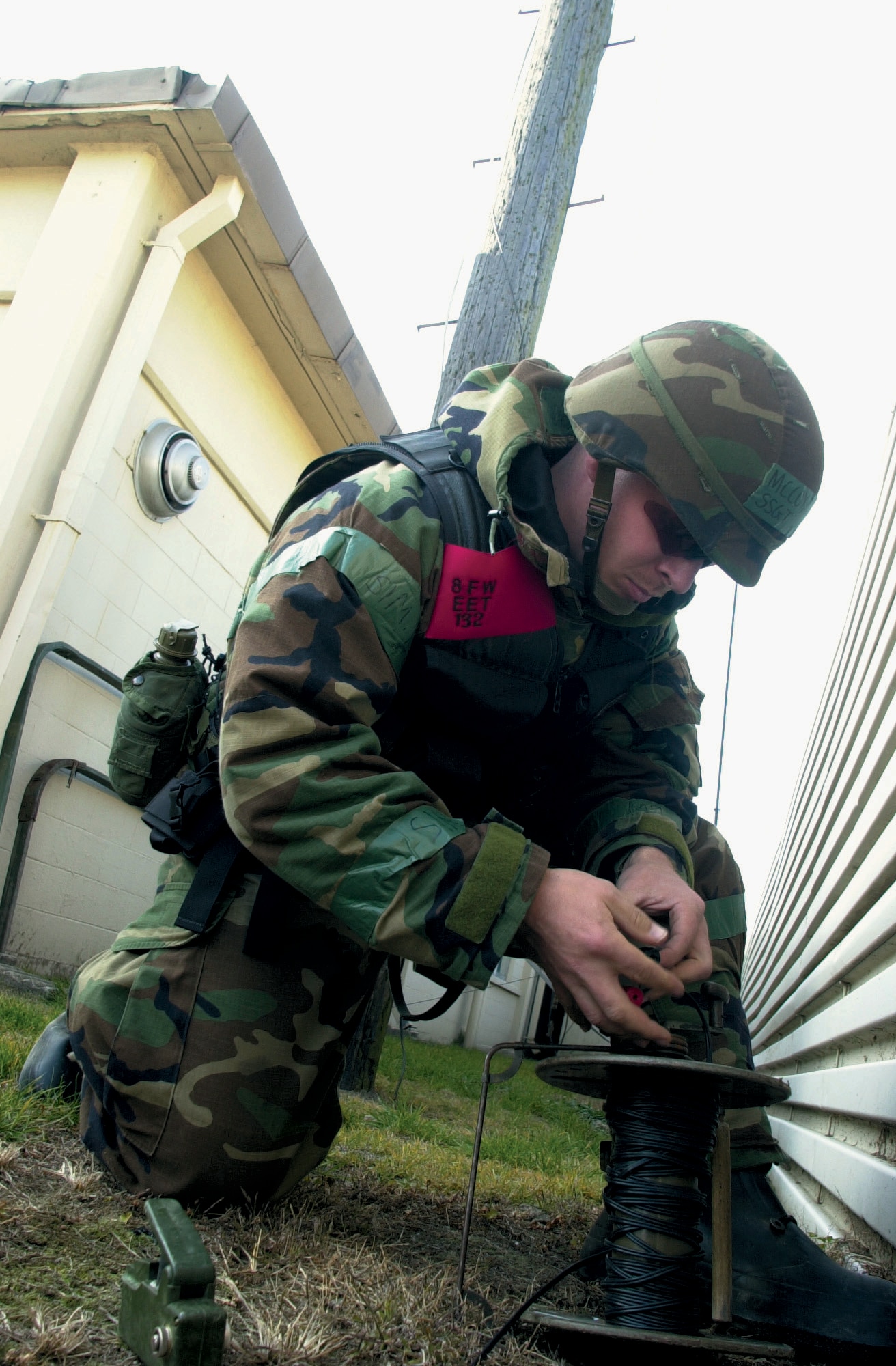 KUNSAN AIR BASE, South Korea -- Staff Sgt. John McCoy wires a remote-firing system Dec. 16 to destroy a Korean War-era bazooka round discovered by Korean airmen.  The remote detonator will send an electrical signal to the military explosive and destroy the rocket.  He is assigned to the 8th Civil Engineer Squadron explosive ordnance disposal flight.  (U.S Air Force Photo by Staff Sgt. Alan Port)