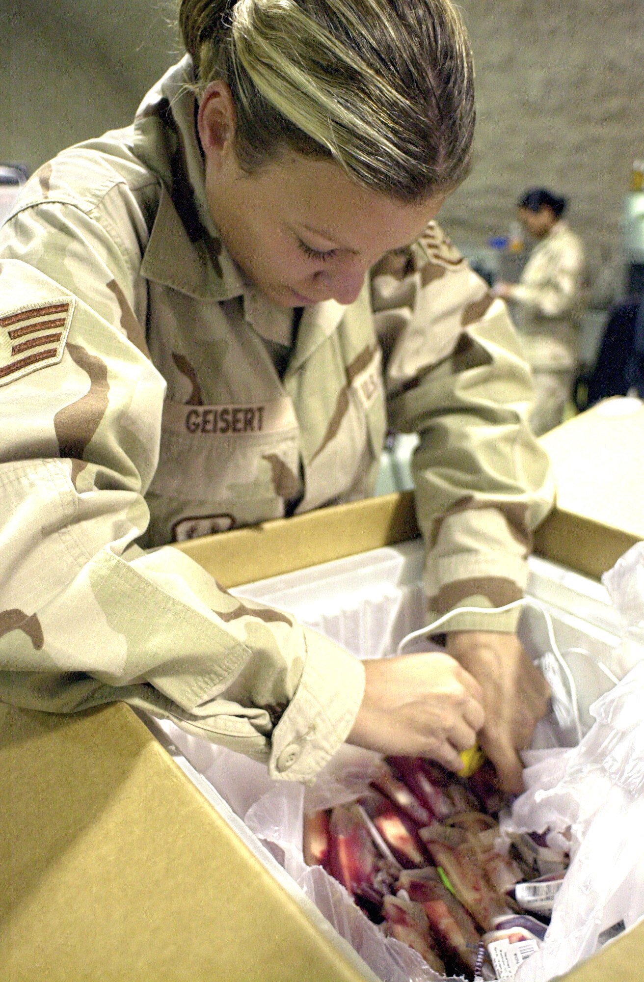 SOUTHWEST ASIA -- Staff Sgt. Amanda Geisert inserts a thermometer into a package filled with packets of red blood cells to ensure the supply has stayed within its required temperature during transport.  She is assigned to the blood transshipment center at a forward-deployed location here.  (U.S. Air Force photo by Staff Sgt. Bryan Bouchard)