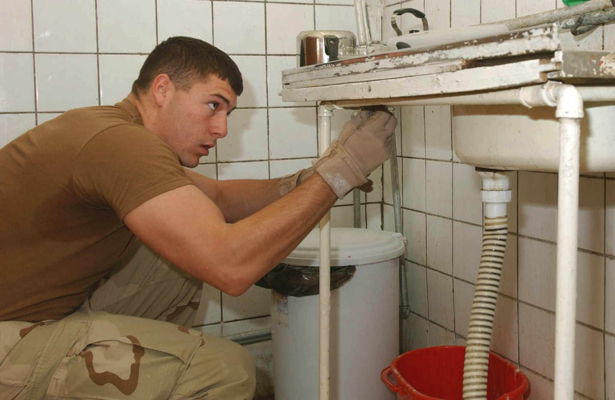 KIRKUK AIR BASE, Iraq -- Airman Joshua Dennison inspects a sink for contraband during a surprise inspection of areas inhabited by third-country workers and American contractors.  He is assigned to the 506th Air Expeditionary Group force protection office.  (U.S. Air Force photo by Staff Sgt. Adrian Cadiz)