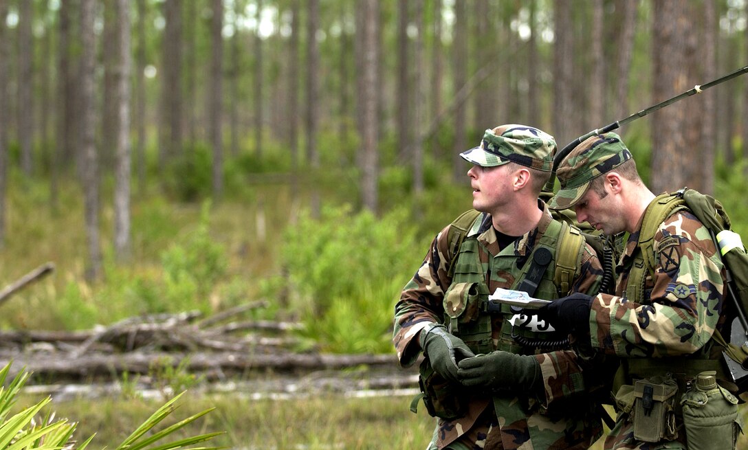AVON PARK, Fla. -- Senior Airman Justin Pilant and Airman 1st Class Daniel Donche confirm their map's coordinates during a land navigation competition at Dragon Challenge 04 here recently. Dragon Challenge is an annual competition  where tactical air control party airmen compete for top honor in physical strength, endurance, mental and emotional challenges.Both Airmen are assigned to the 20th Air Support Operations Squadron , Fort Drum, N.Y. (U.S.Air Force photo by Senior Airman Lapedra P. Tolson)