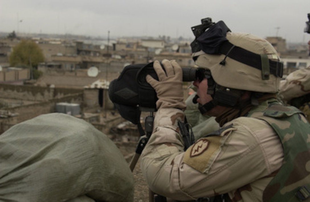 A U.S. Army soldier scans for insurgent activity from the rooftop of number 3 West Police Station in Mosul, Iraq, on Dec. 12, 2004. The soldiers assigned to Charlie Company, 1st Battalion, 24th Infantry Regiment, 1st Brigade, 25th Infantry Division Stryker Brigade Combat Team are occupying the station. 