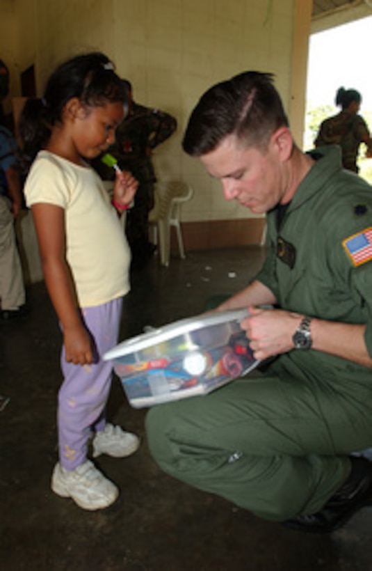 Air Force Lt. Col. Theodore Corallo helps a Honduran girl open her gift at an orphanage in Honduras on Dec. 8, 2004. Members of the 16th Special Operations Wing of Hurlburt Field, Fla., have been delivering donated gifts to the Honduran orphanage for 14 years. 