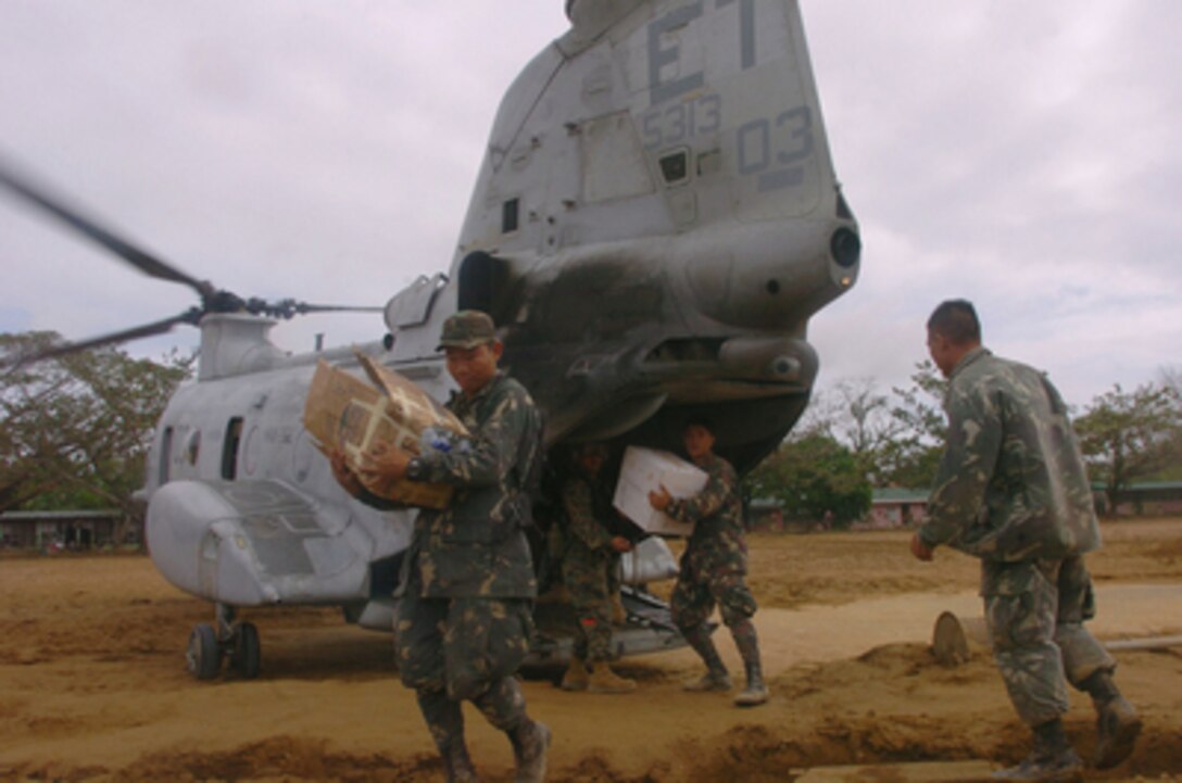 Philippine military personnel unload supplies from a U.S. Marine Corps CH-46E Sea Knight helicopter during typhoon relief operations in the Quezon Province of the Philippines on Dec. 14, 2004. About 600 U.S. military men and women are in the Philippines providing humanitarian assistance and disaster relief to residents of Quezon where widespread flooding and landslides have occurred. U.S. Marine and Air Force helicopters are flying daily relief missions to the stricken areas. 
