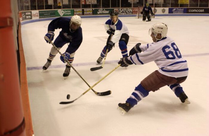 CHARLESTON, S.C. -- Paul Goff, No. 68, and Russ Killpartrick fight a Navy defender for control of the puck.  The Airmen prevailed and scored the third goal of the game.  The Air Force hockey team is from nearby Charleston Air Force Base.  They defeated the Navy team 6-5.  (U.S. Air Force photo by Staff Sgt. Matthew Hannen)