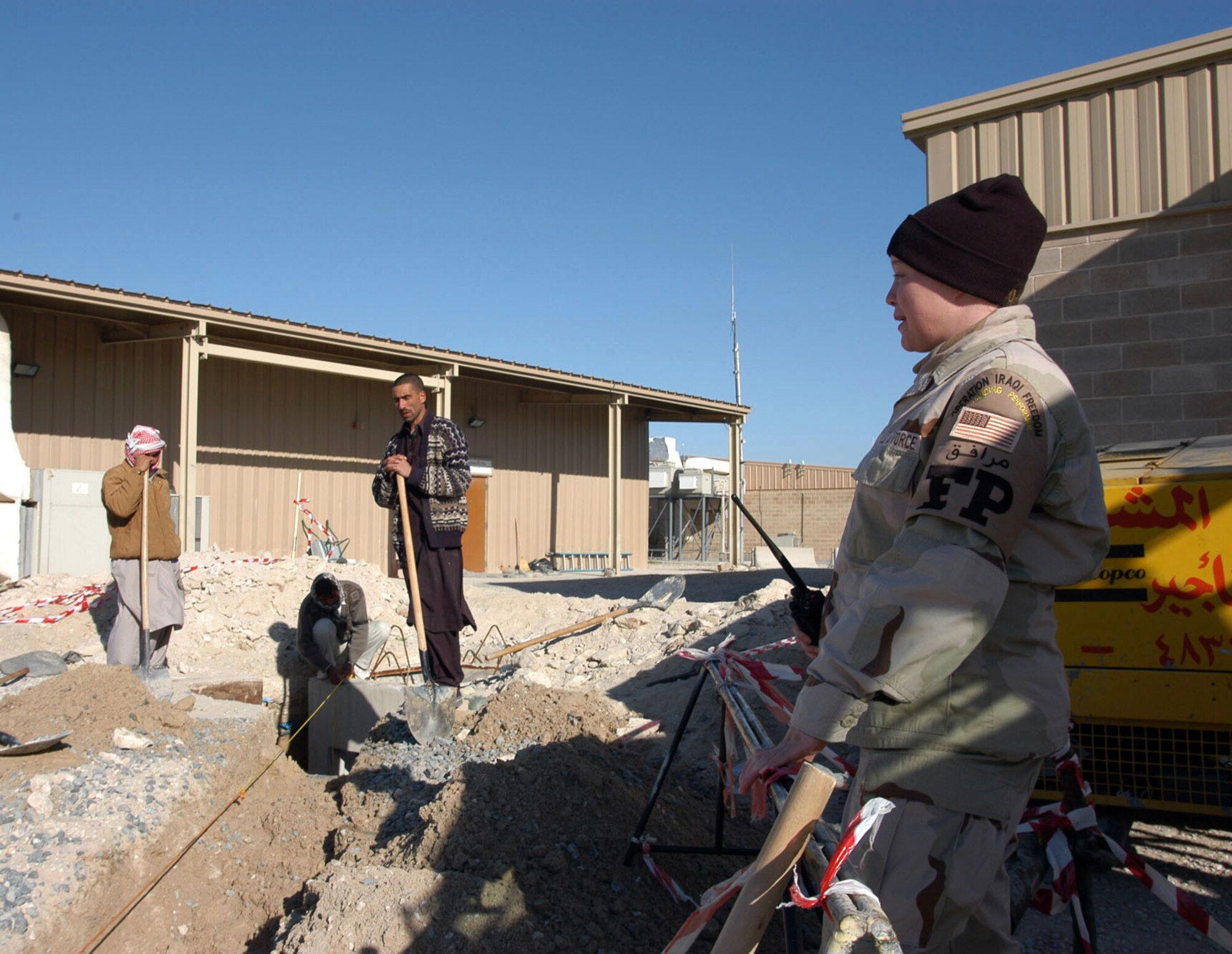 SOUTHWEST ASIA -- Airman 1st Class Christina Colvin watches third-country workers at a construction project at a forward-deployed location.  The force protection flight Airmen help ensure the safety of the base by escorting more than 2,300 workers who transit the base weekly.  Airman Colvin is assigned to the 386th Expeditionary Security Forces Squadron force protection flight.  (U.S. Air Force photo by Capt. Aaron Burgstein)